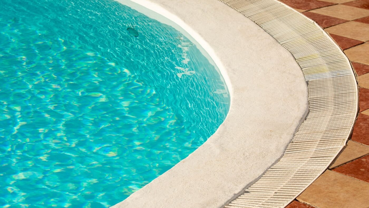Curved swimming pool edge finished with smooth rounded coping, the rounded profile bullnose pavers create