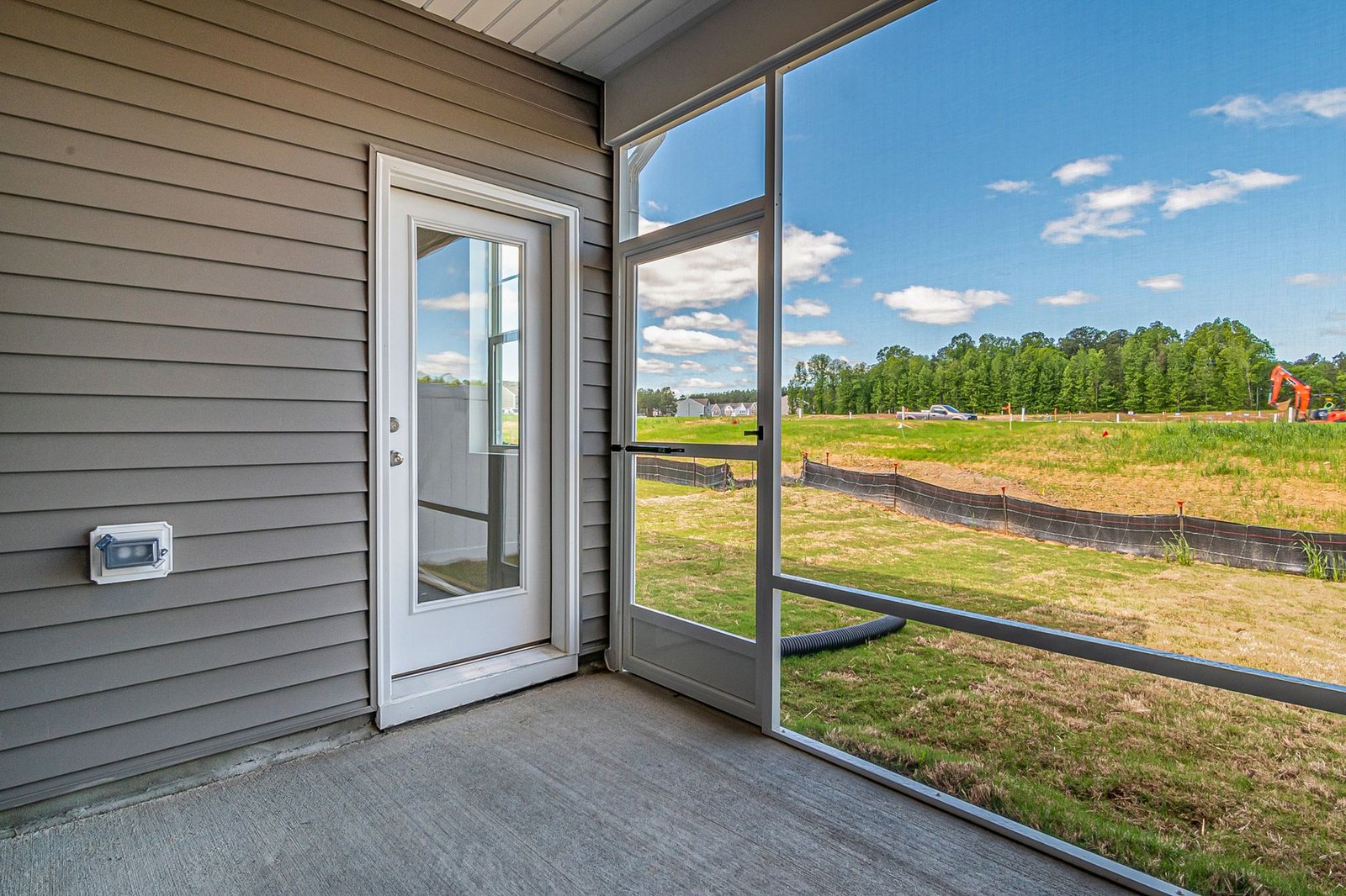 Bare concrete slab on the screened back porch of a newly built house
