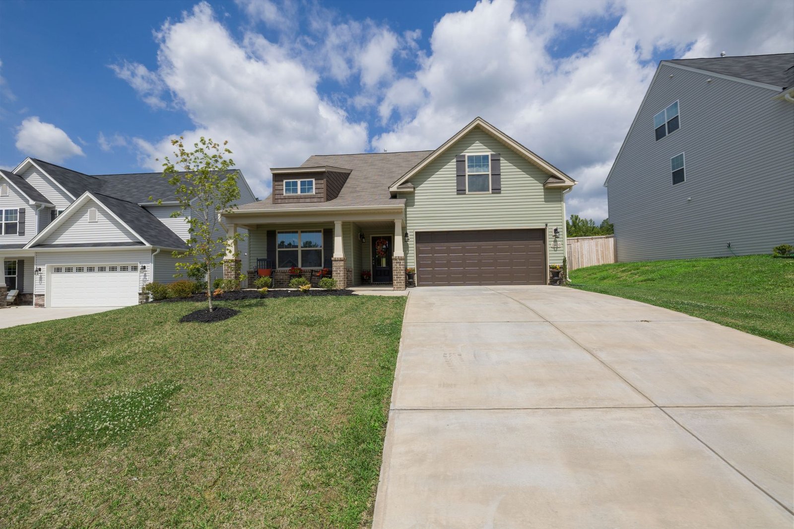 Plain concrete driveway leading to a single garage, the kind of slab a paver extension widens