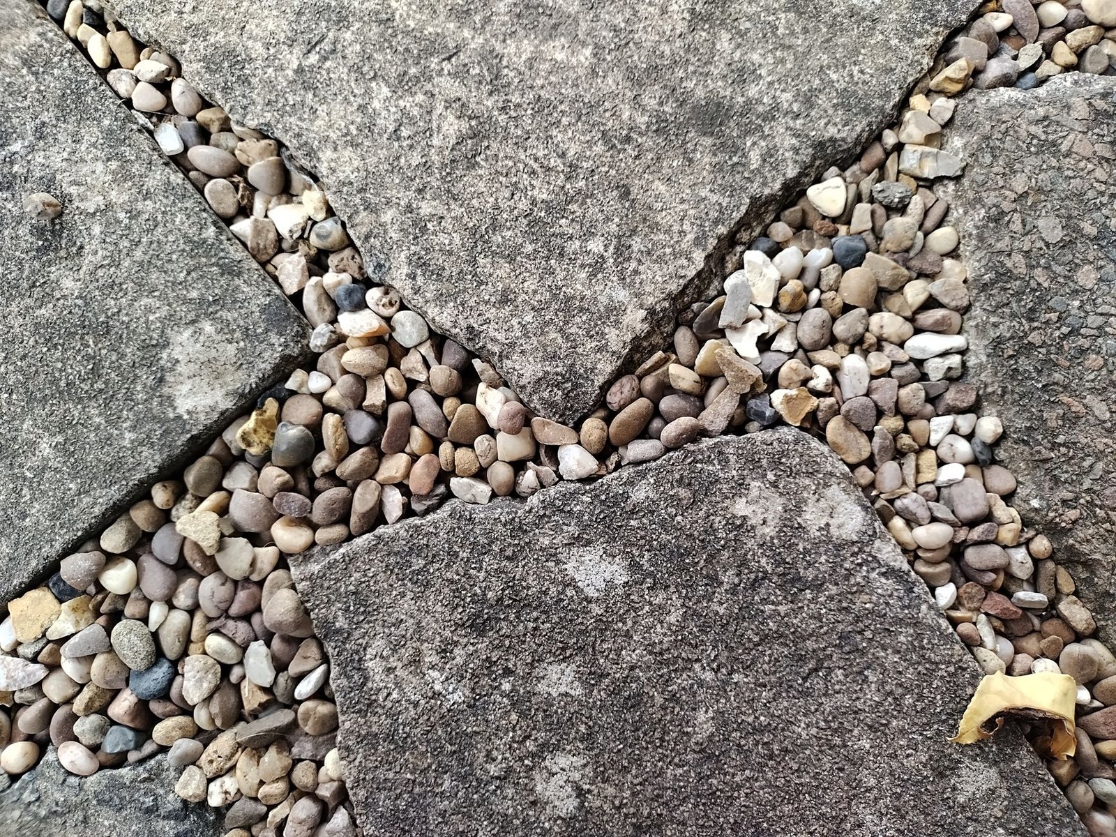 Gray flagstones with joints filled with small rounded pea gravel pebbles