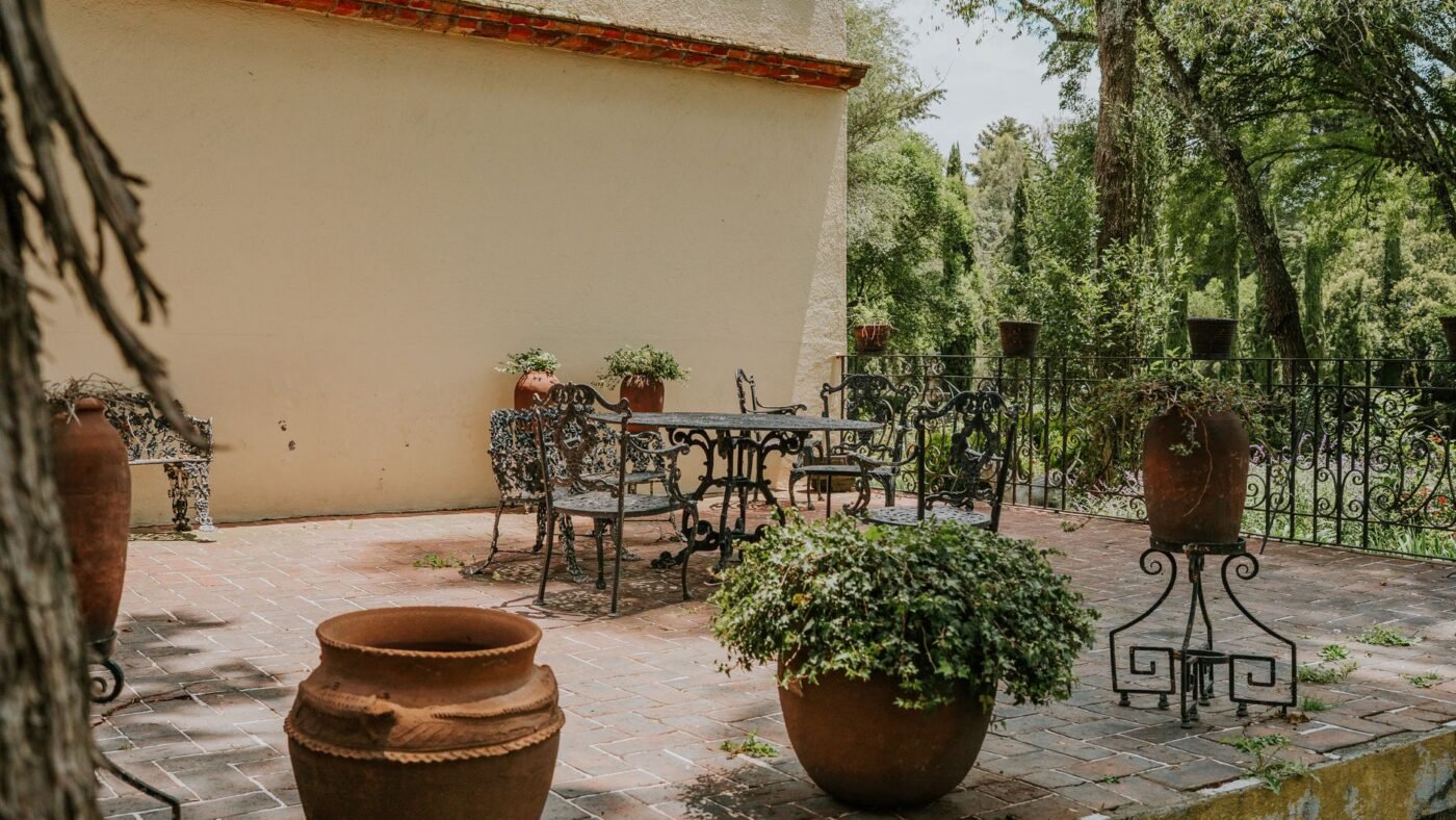 Brick paver patio with wrought iron furniture and large terracotta pots, a surface whose paver count starts with its square footage