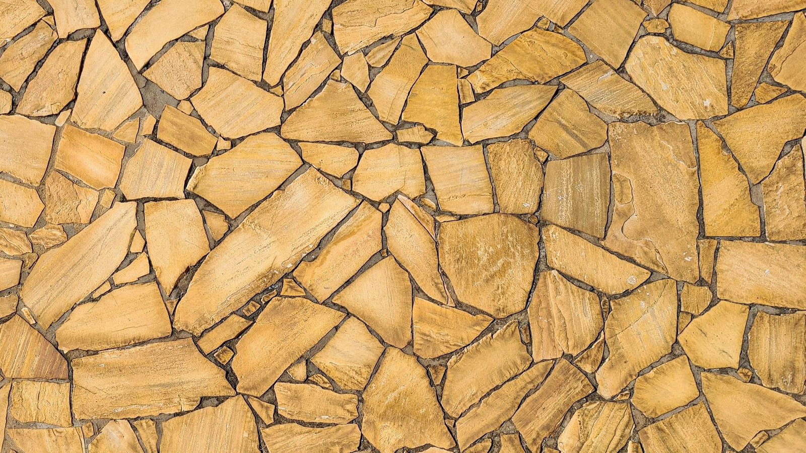 Top view of irregular tan flagstone pieces with wide, uneven joints between them