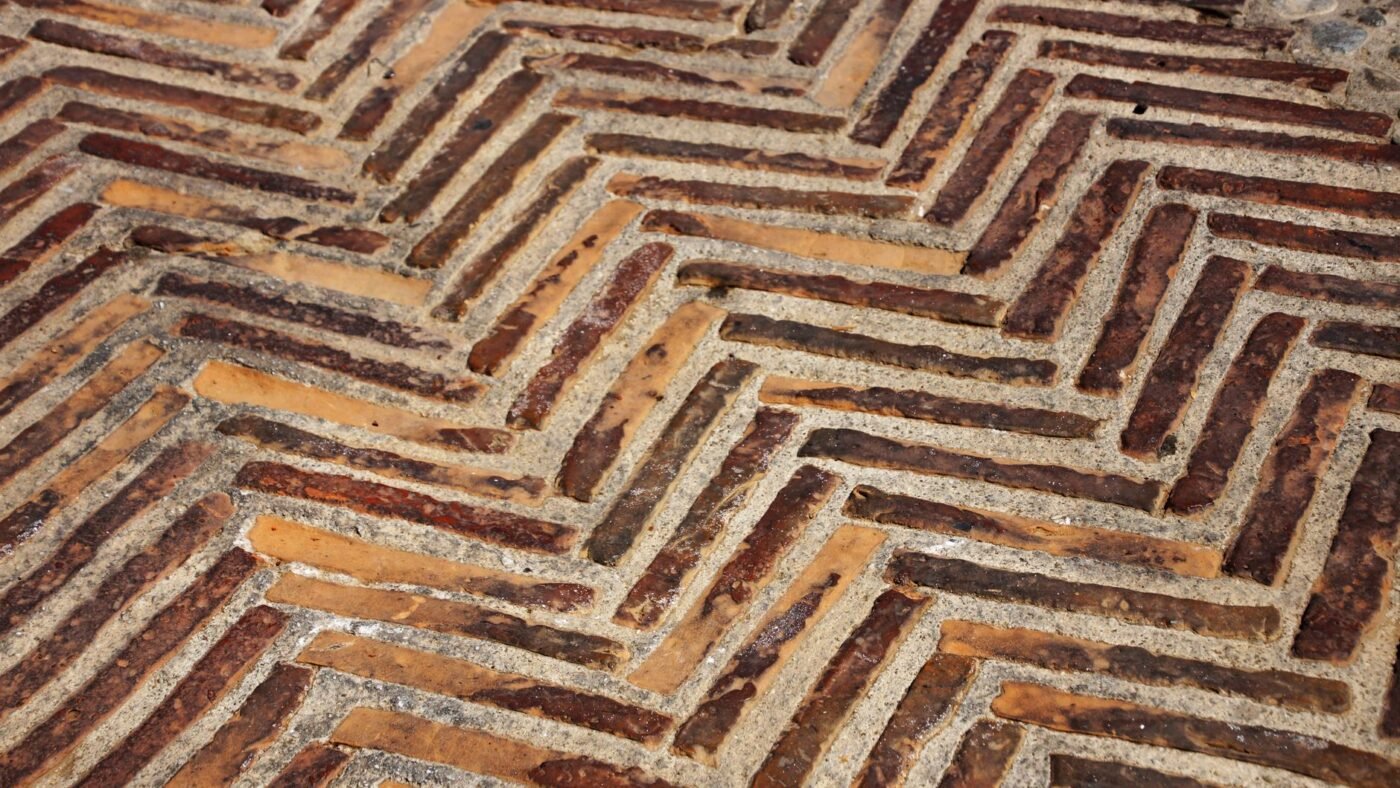 Herringbone brick paving with many sand-filled joints, showing how small pavers create more joint length per square foot