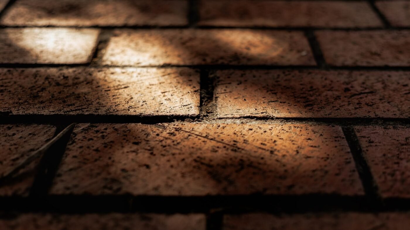 Brick pavers in running bond with narrow dark joints between them, the kind of joints polymeric sand is applied to