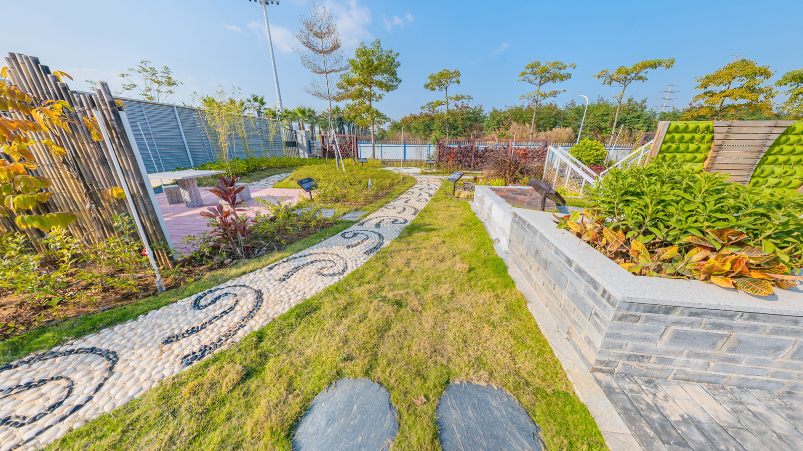 Two round concrete stepping stones set into a lawn beside a pebble garden path