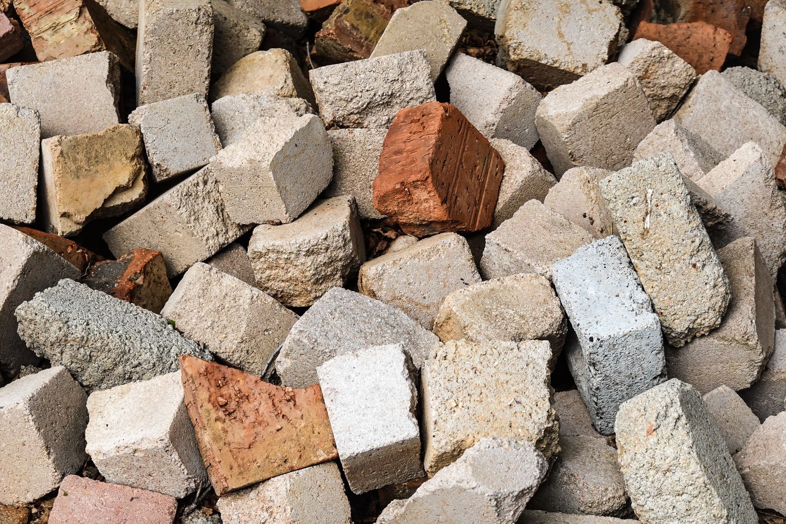 Pile of broken concrete blocks and bricks, the kind of masonry debris left after removing old pavers