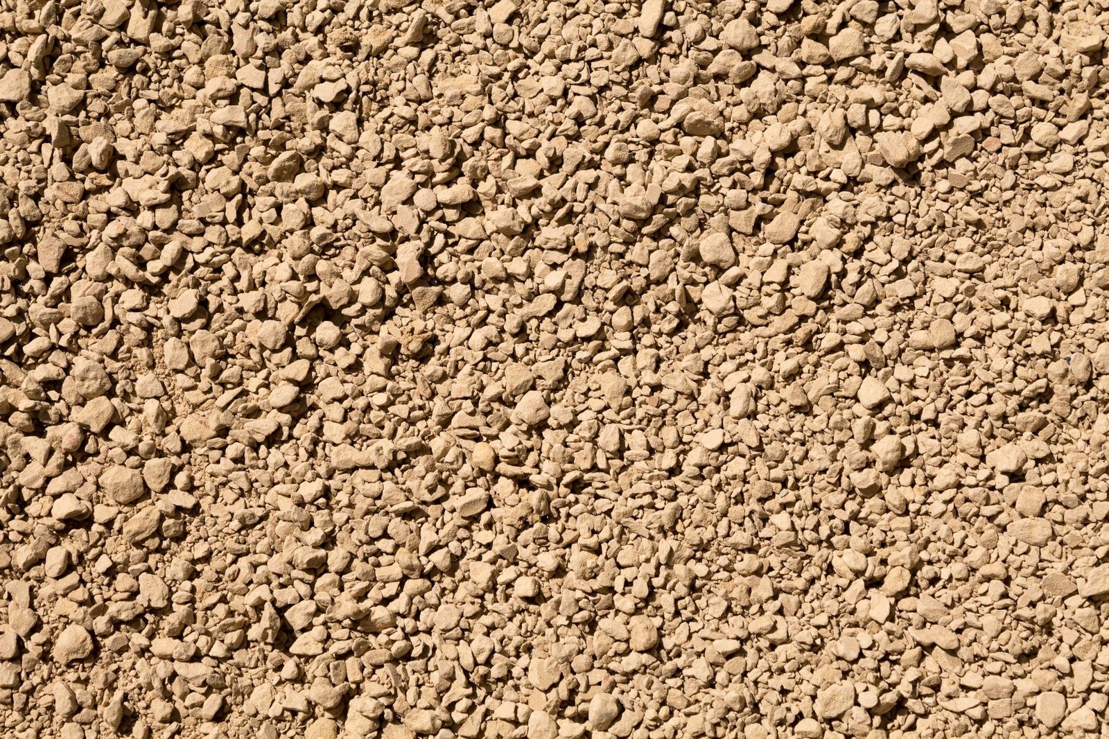 Close-up of dense-graded crushed stone with fines, the standard base material for pavers