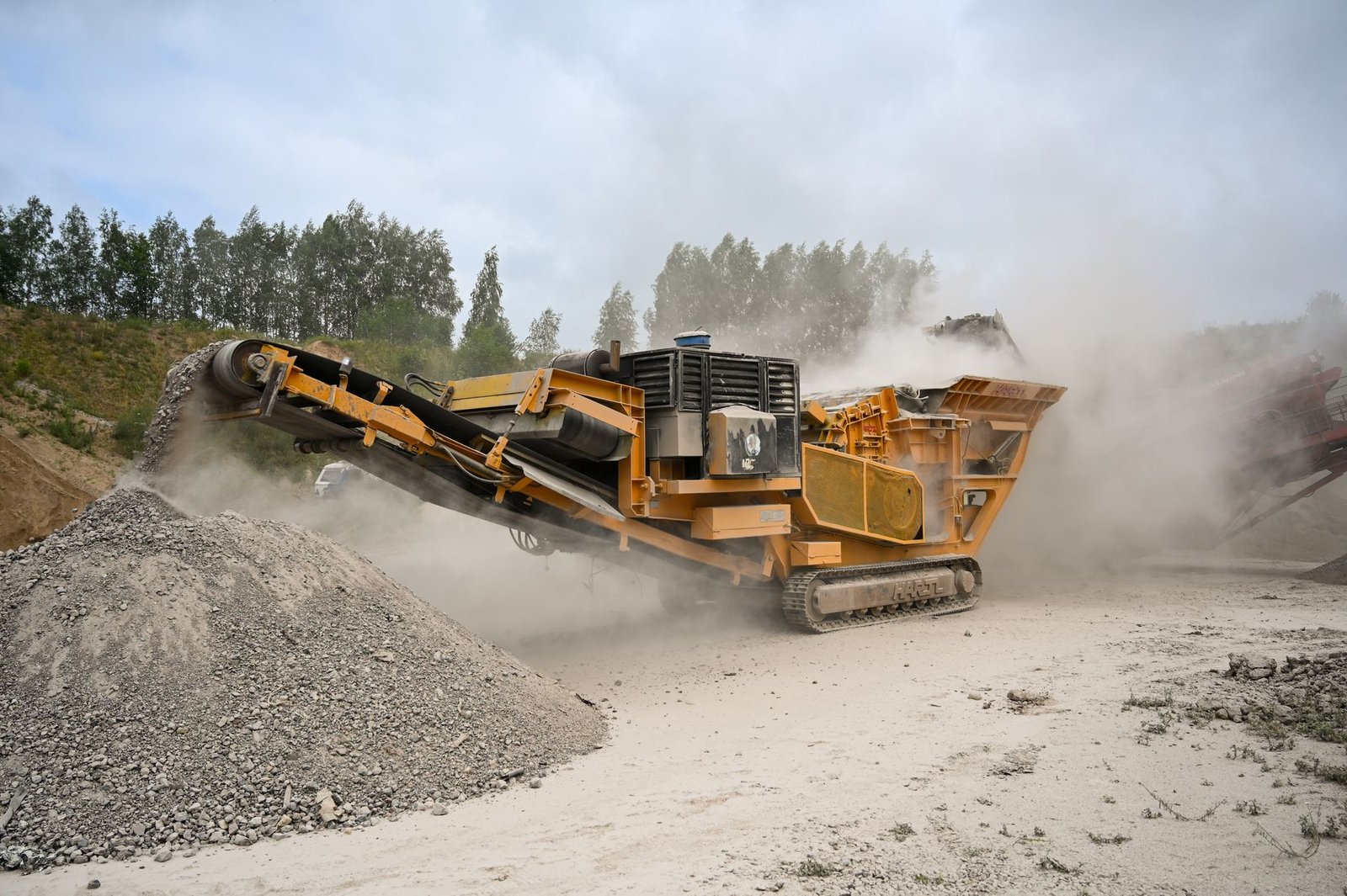 Mobile crusher producing a pile of crushed aggregate, similar to how recycled concrete paver base is made