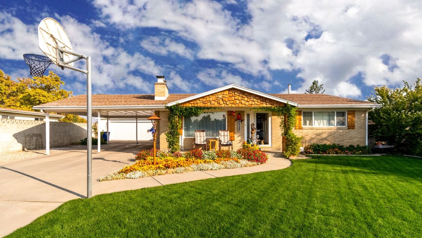 Front yard flower bed with a curved light-colored curb separating it from a green lawn