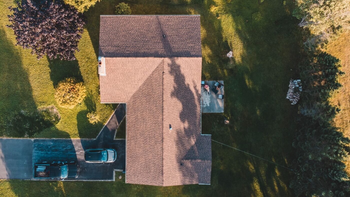Aerial view of a house with two cars on its driveway, the area that sets paver driveway cost