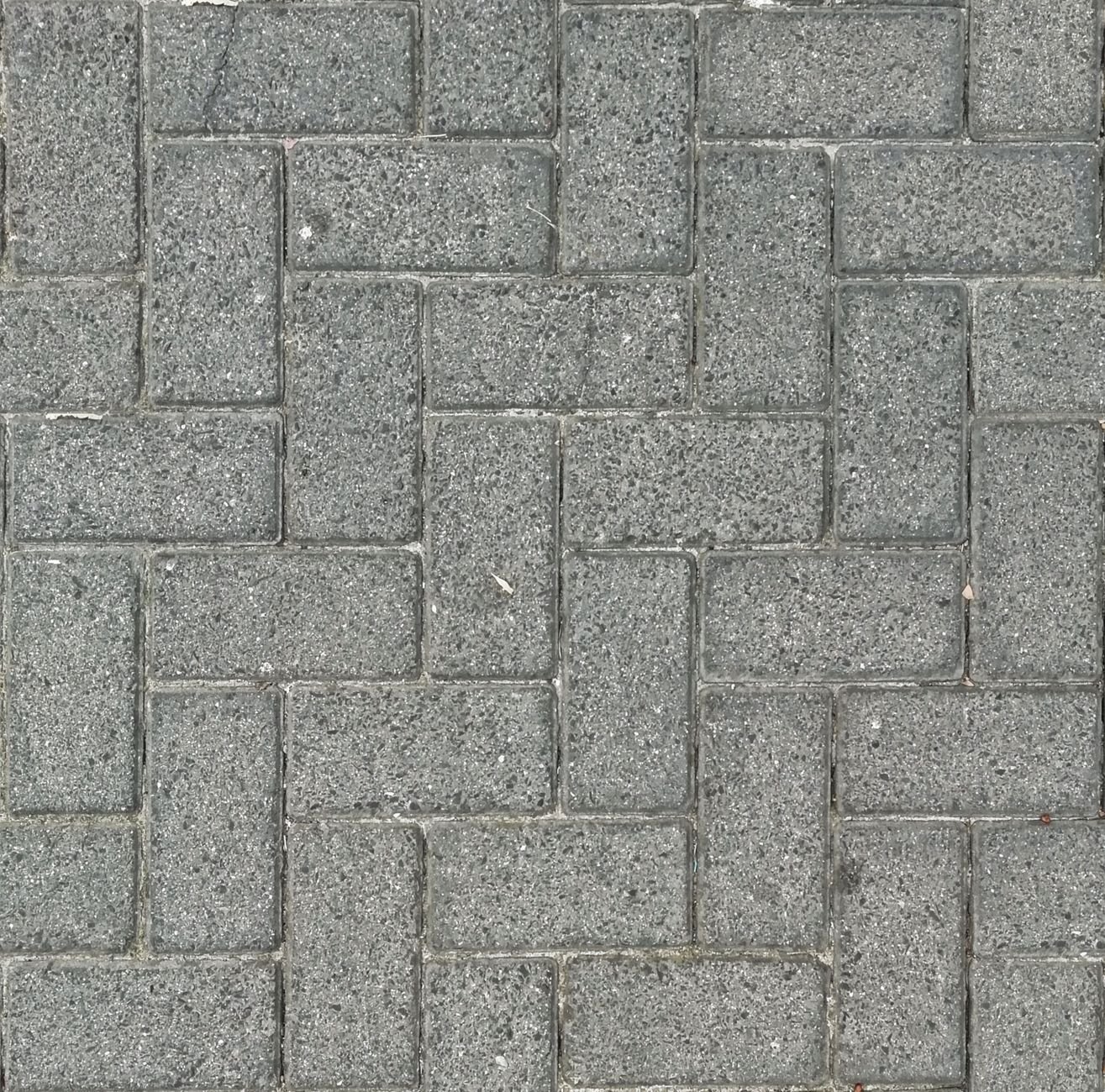 Gray concrete pavers laid in a tight herringbone pattern seen from above