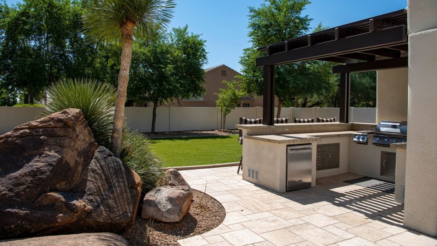 Clean, well-kept paver patio with an outdoor kitchen and pergola, the result of regular paver maintenance