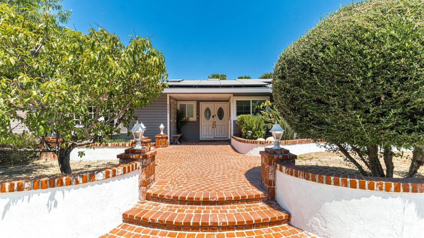 Red brick paver walkway with two curved steps leading to a front door