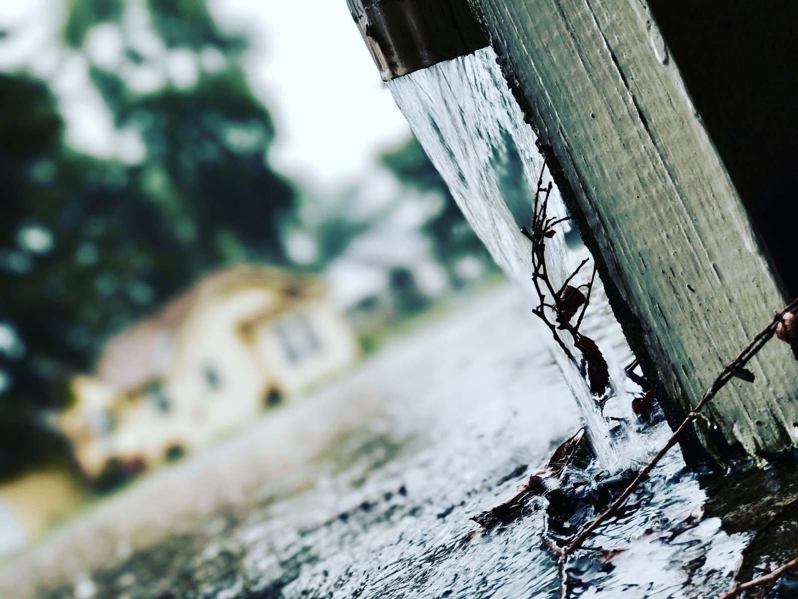 Rainwater pouring off a roof edge, the runoff a patio next to the house has to carry away