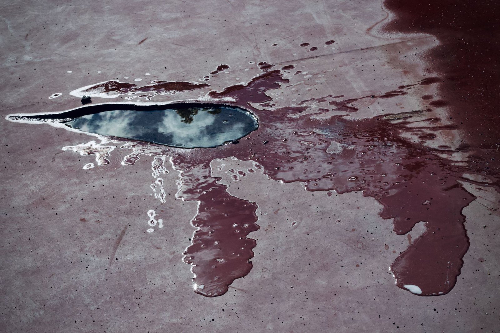 Standing water pooled on a concrete slab after rain, showing why drainage matters before putting pavers on concrete