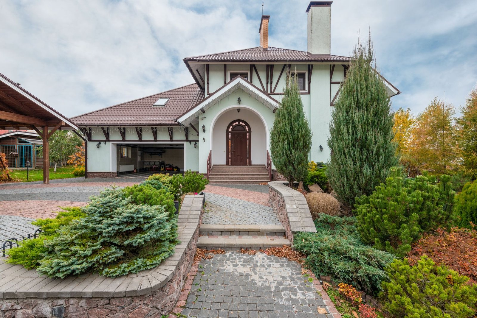 Paver entry walk leading to front steps and a door, where the added height of pavers on top of concrete must be planned