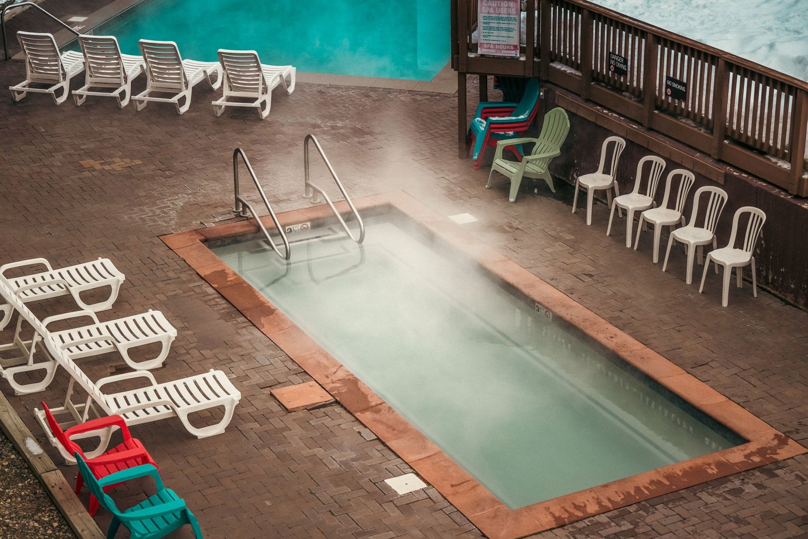Paver pool deck around a steaming pool with loungers, where a slippery film sealer is a drawback and a penetrating sealer is the safer choice