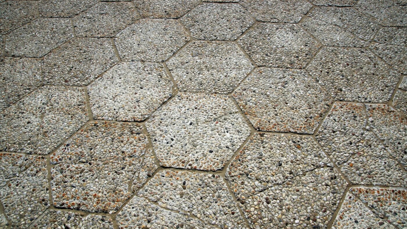 Hexagonal concrete pavers with sand for pavers packed into the joints between each stone