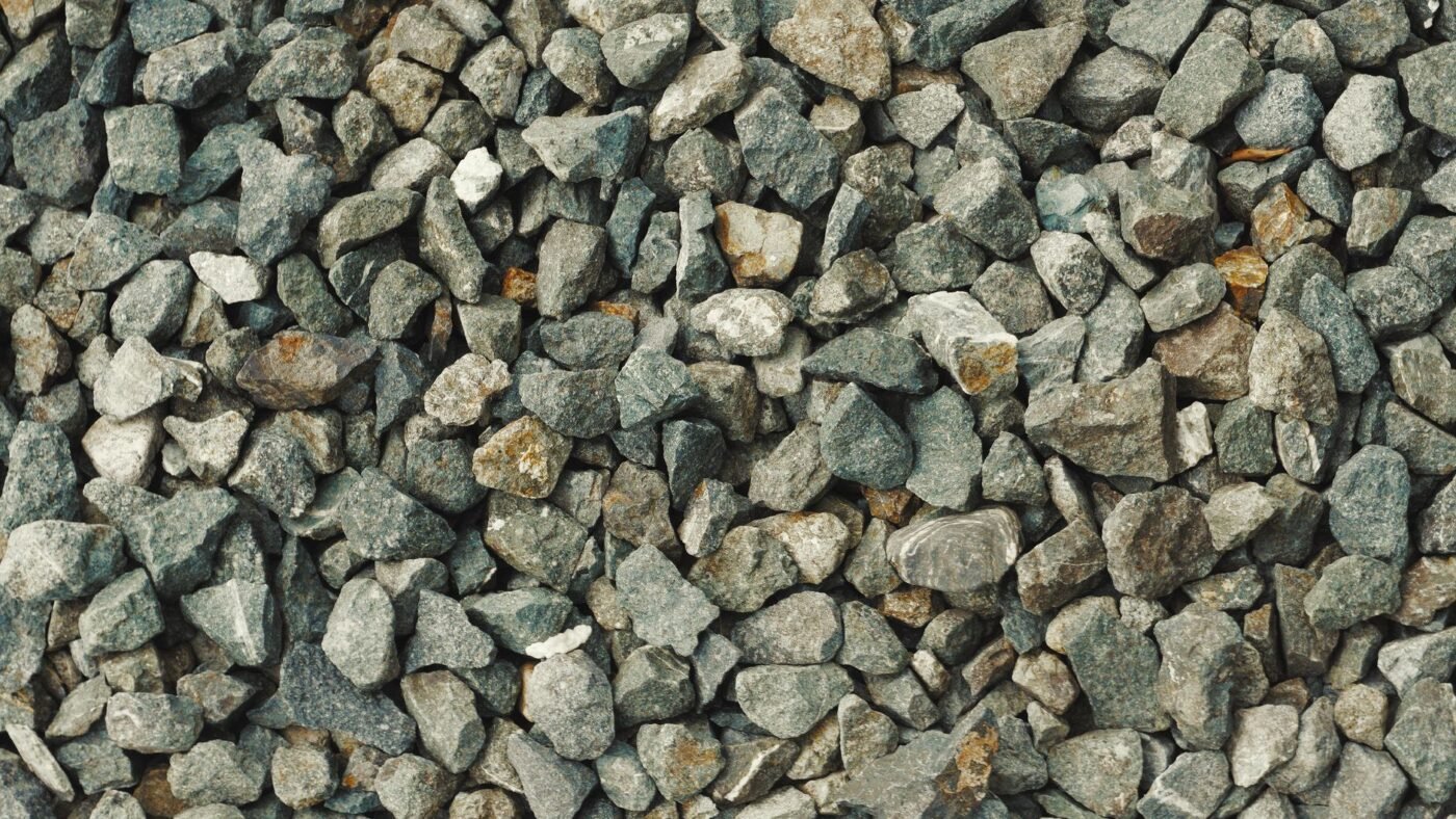 Close-up of angular gray crushed stone, the granular base material a vibratory plate compactor is built to compact